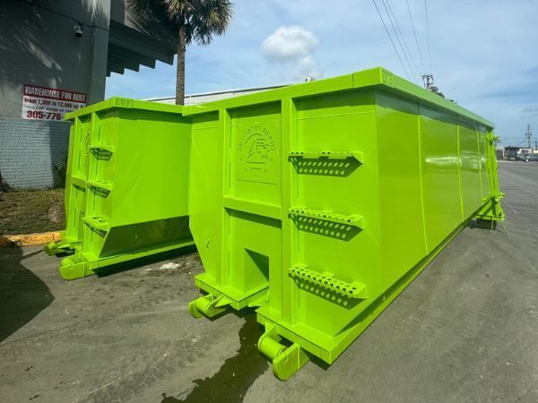 Bright neon-green metal shipping container bins parked outdoors on a street.