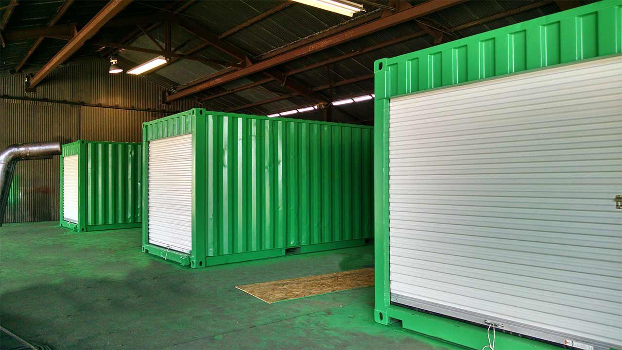 modified containers painted green and white in a self storage facility