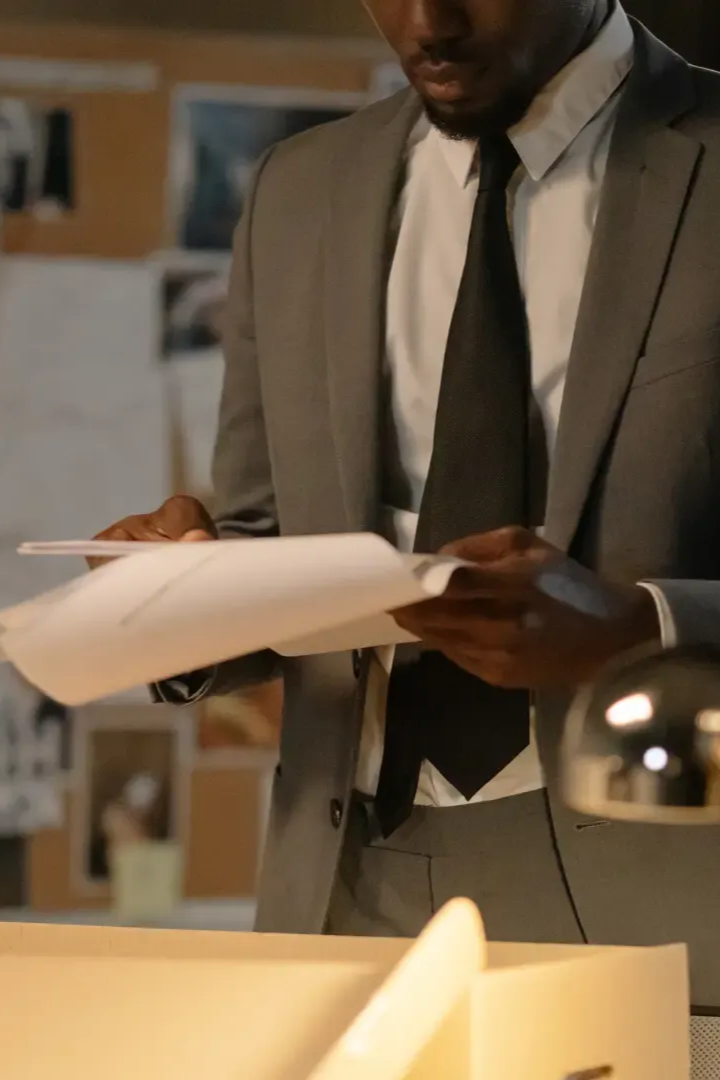 Licensed private investigator reviewing confidential case files and paperwork in a Fort Myers, FL office for W&W Solutions Inc.