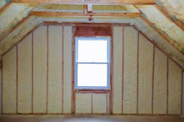 Empty attic interior with exposed rafters and a single centered window