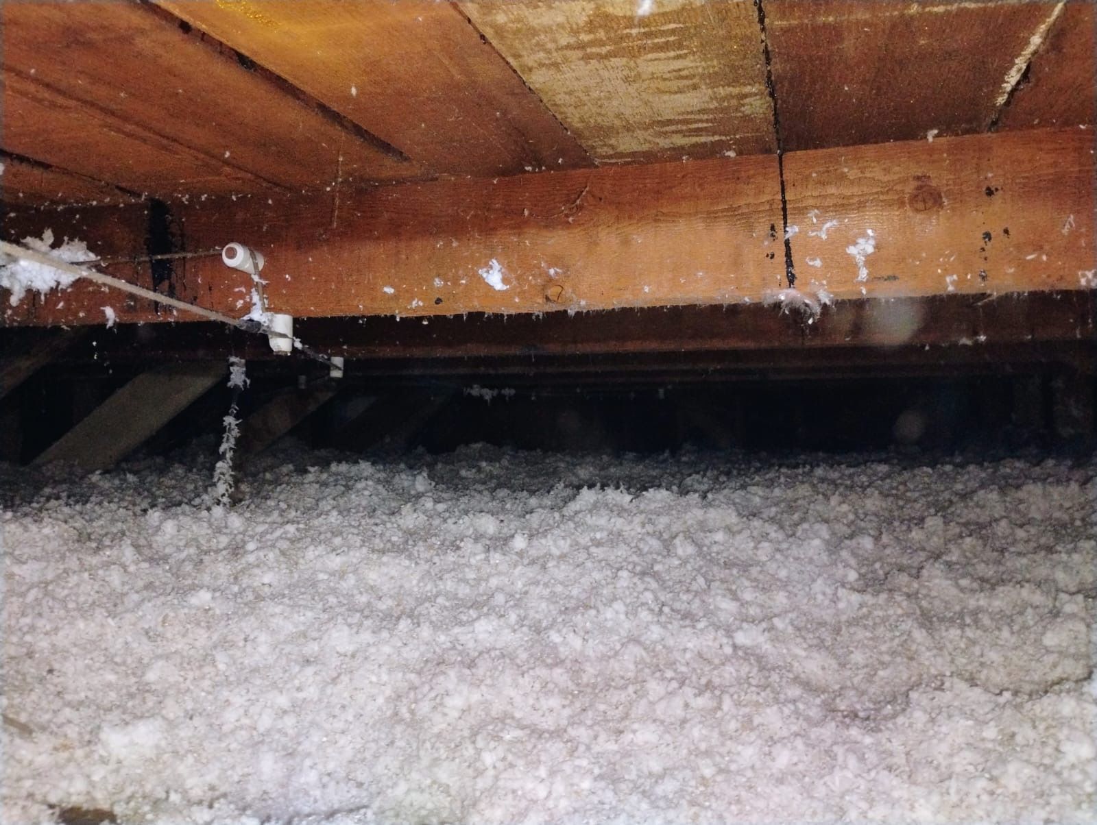 Foam insulation filling a wooden attic space under the roof