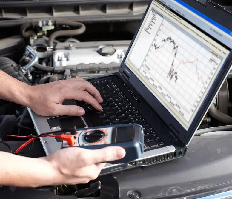 Mechanic Using Diagnostic Tool on Car Engine in a Garage — D R Automotive in Russell Vale, NSW