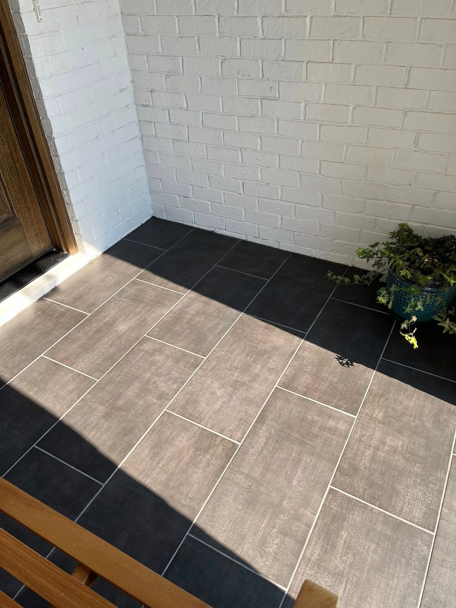 A tiled floor with a brick wall in the background