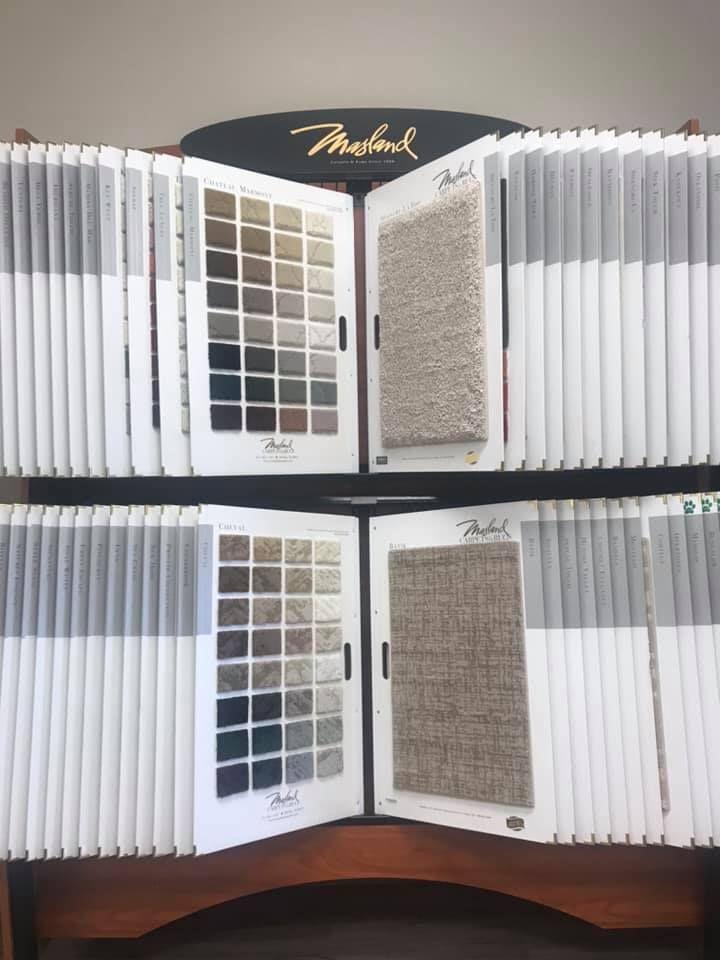A display of carpet samples is sitting on top of a wooden table.