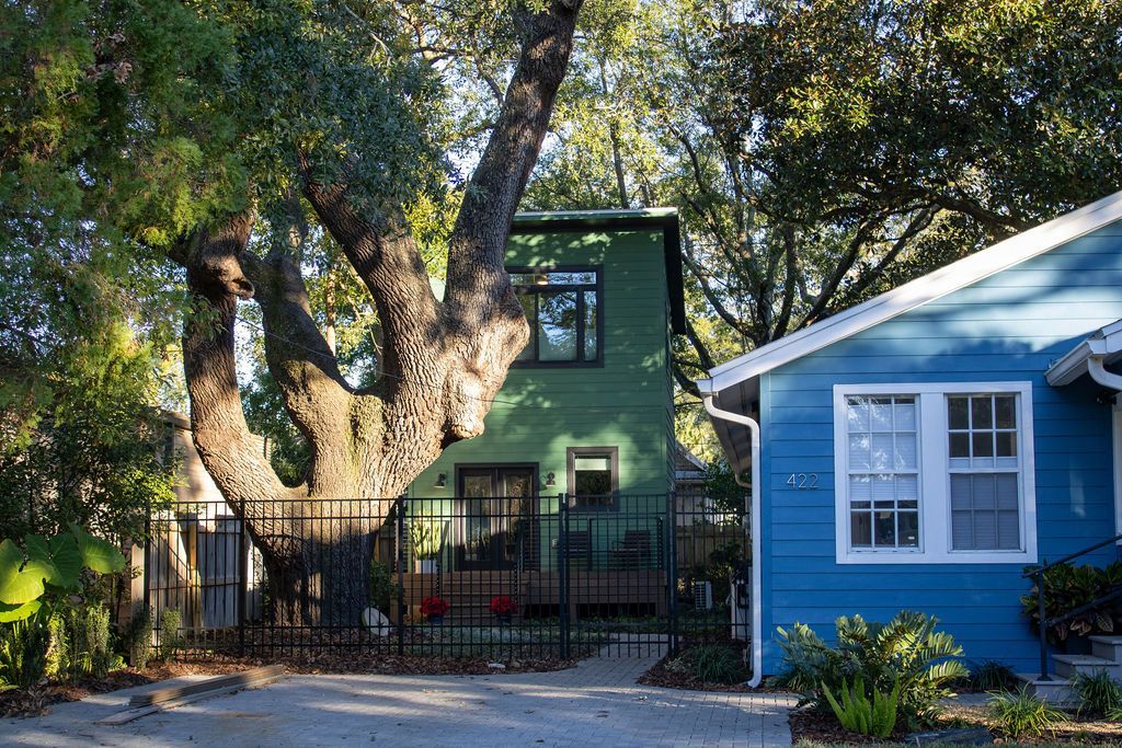 A blue house with a green house in the background