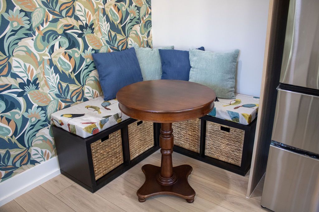 There is a table and a bench in the corner of the room.