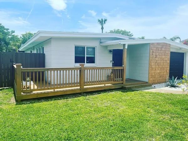 a white house with a wooden deck in front of it