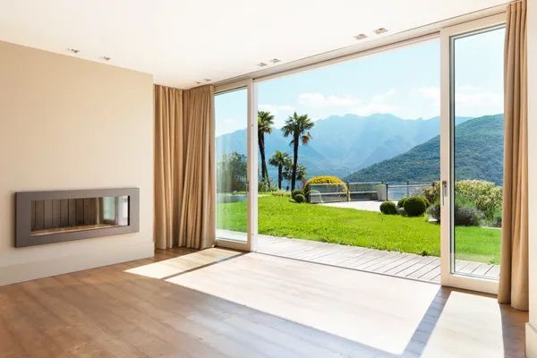 a living room with a fireplace, sliding glass doors, and a view of the mountains