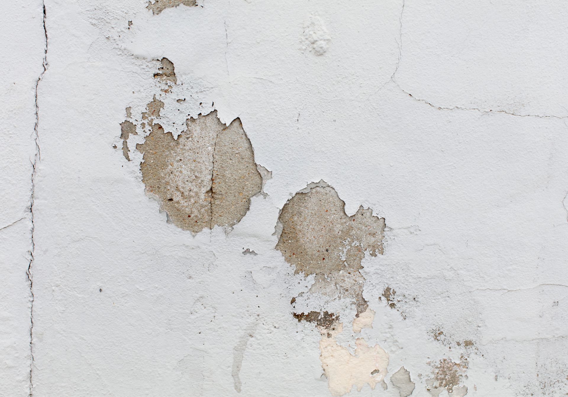 A close up of a white wall with stains on it.
