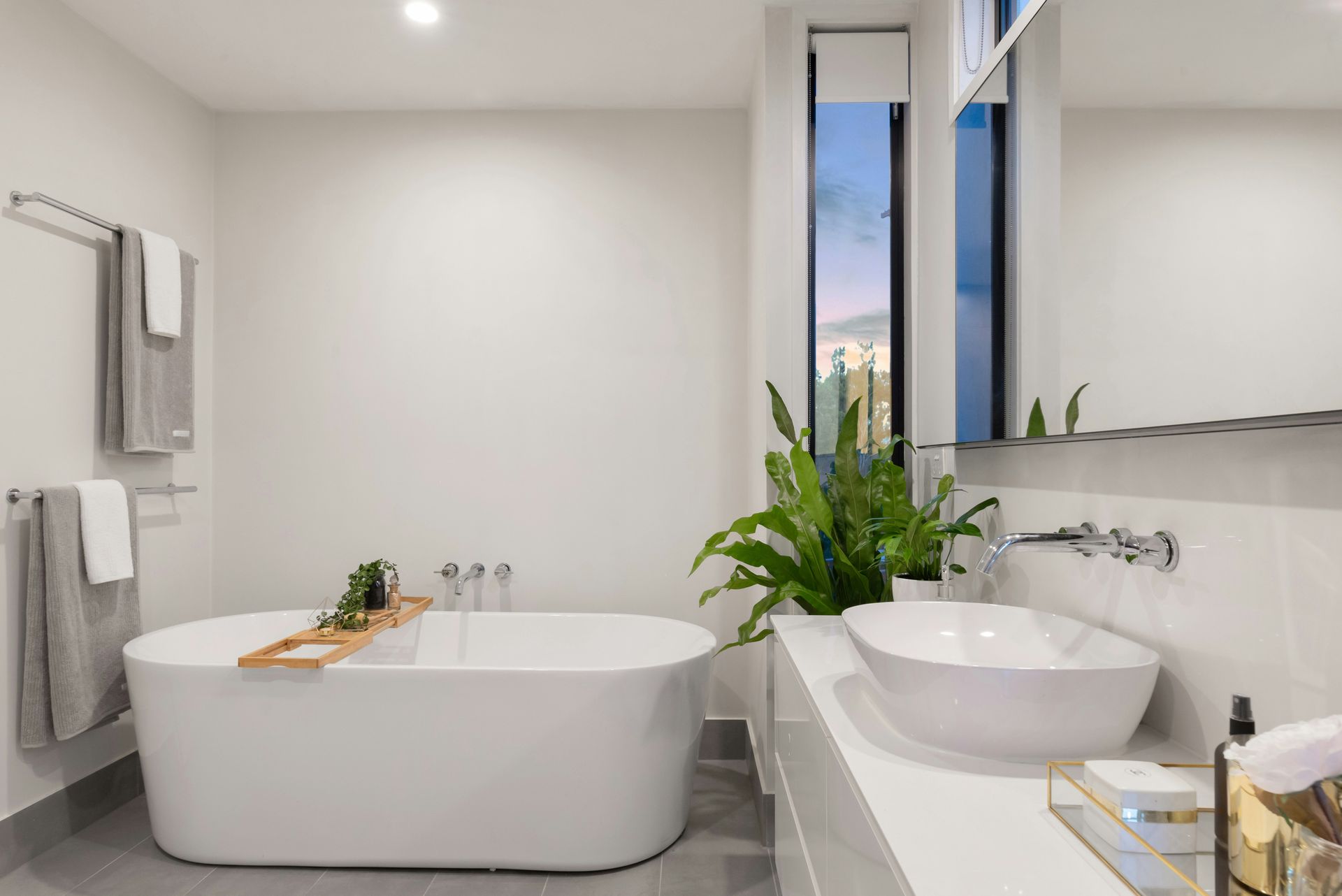 A bathroom with a tub , sink and mirror.