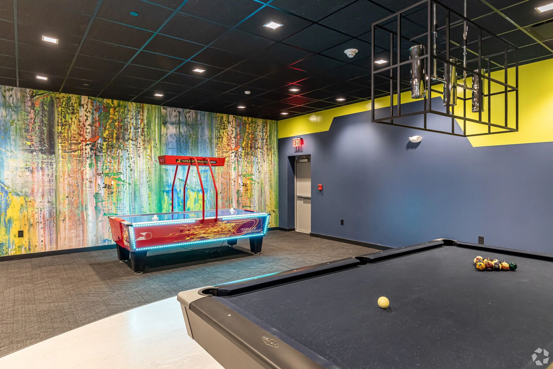 Resident game room with pool table and lounge space at The Millennium apartments