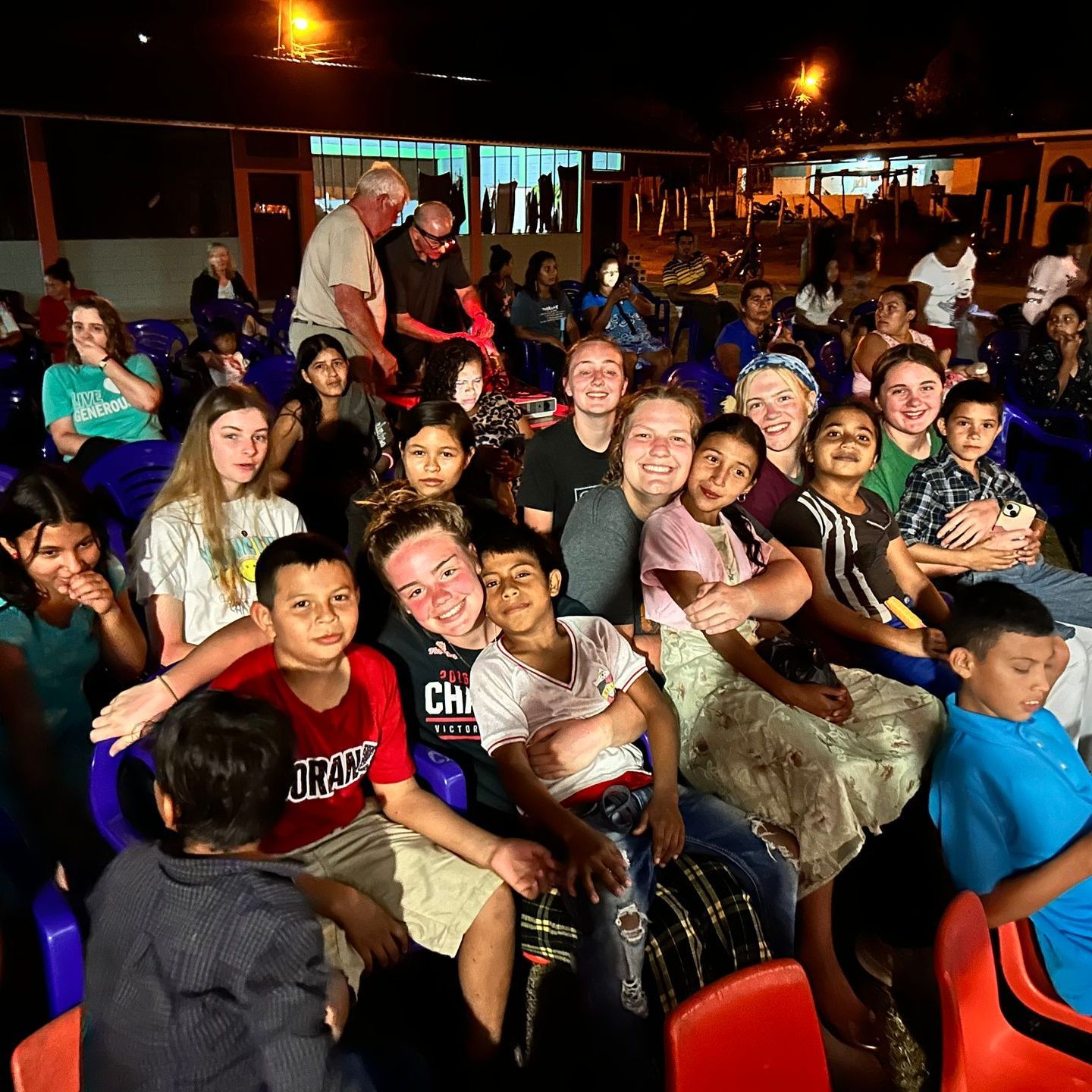 A traveling team of youths makes friends with children at a school.