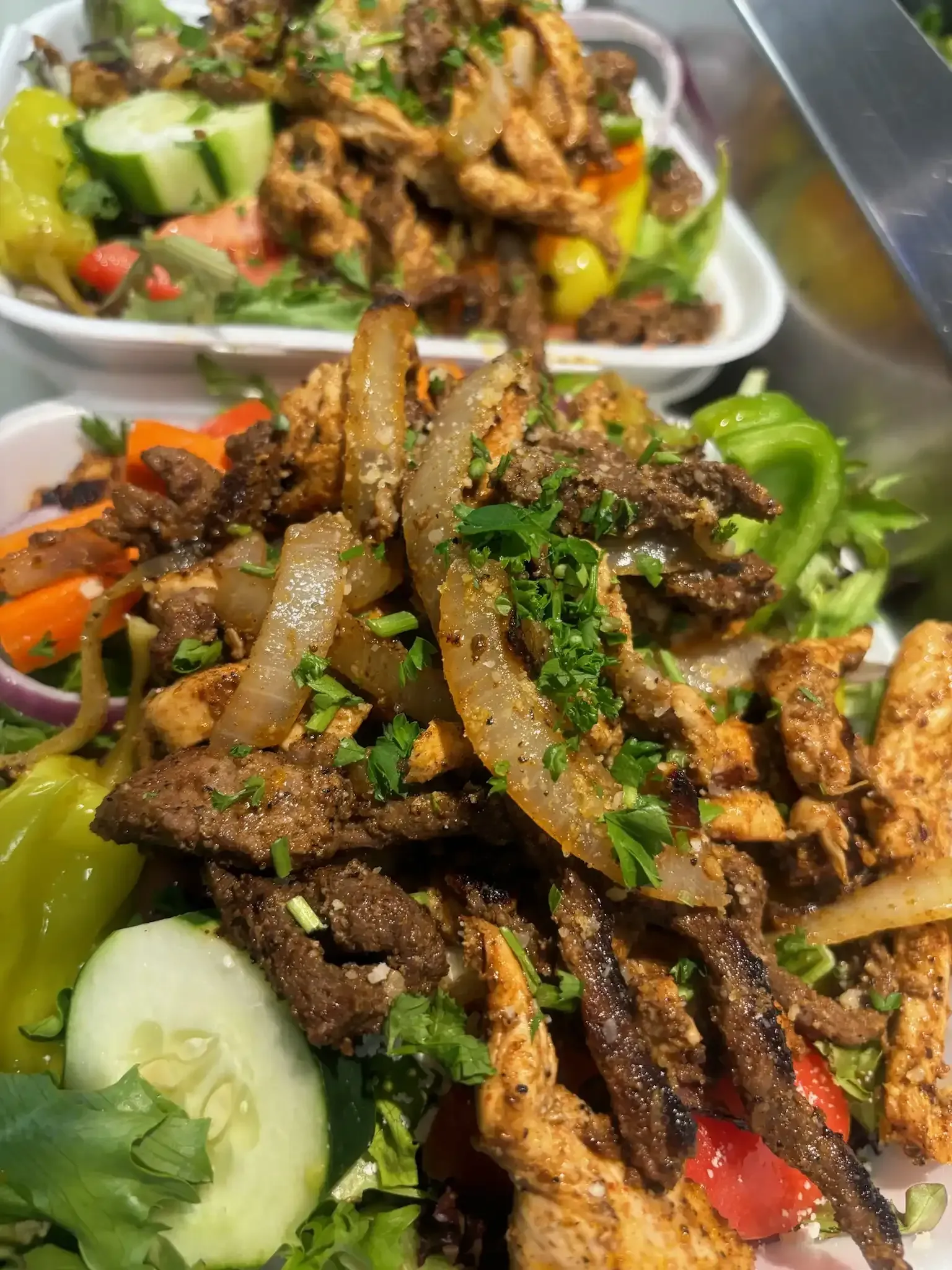 A close up of a plate of food with meat and vegetables on a table.