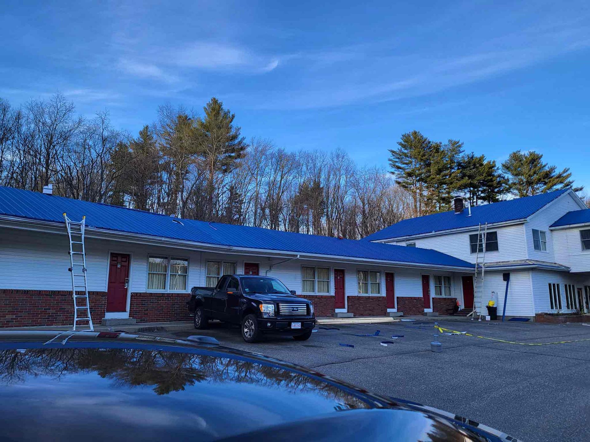 A Black Truck Is Parked In Front Of A Motel With A Blue Roof — Brimfield, MA — RMD Services, Inc. A Black Truck Is Parked In Front Of A Motel With A Blue Roof — Brimfield, MA — RMD Services, Inc.