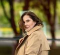 Sheila Wysocki in a trench coat looking at the camera.