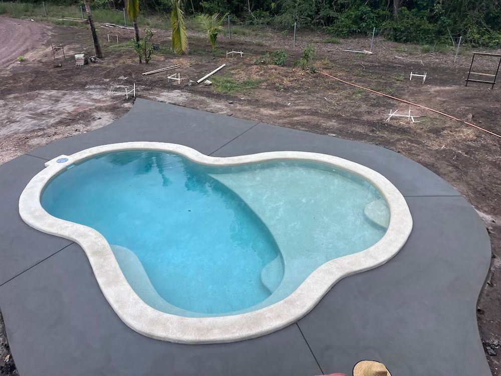Swimming Pool Filled With Water, Surrounded by Gray Concrete and Tan Coping — Mobcon Construction in Dundee Beach, NT