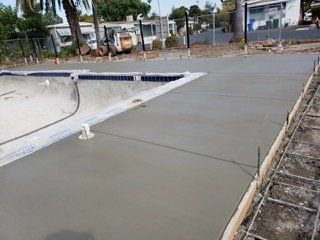 A concrete driveway is being built next to a swimming pool. A concrete driveway is being built next to a swimming pool.