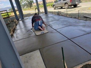 A man is laying on a concrete floor. A man is laying on a concrete floor.