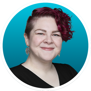 Studio portrait of a smiling person with magenta hair against a teal background