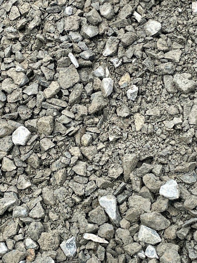 a pile of rocks and dirt on the ground . Crushed Class 7 base rock materials