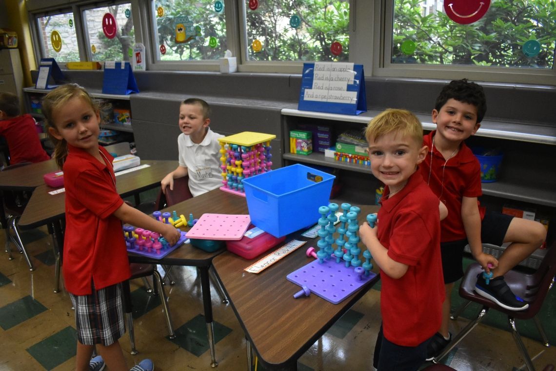 A group of children are playing with toys in a classroom