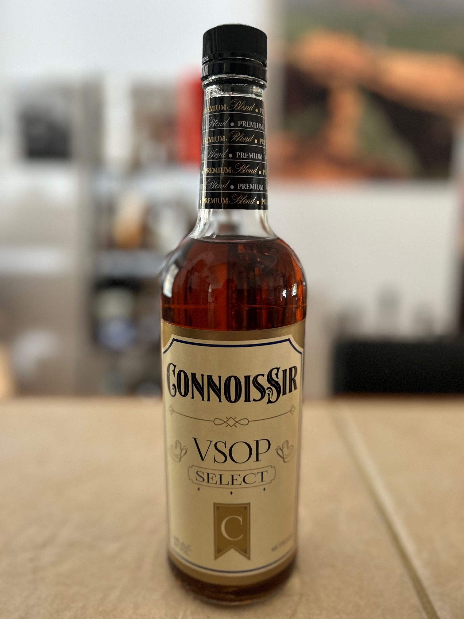A bottle of connoisseur vsop is sitting on a wooden table.
