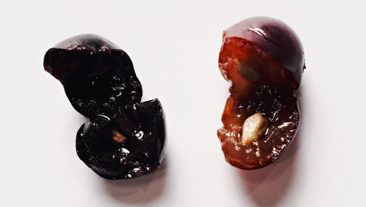 A close up of a cherry with a bite taken out of it