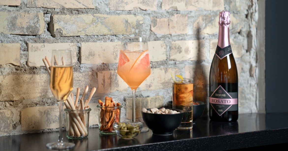 A bottle of champagne is sitting on a counter next to a glass of champagne.