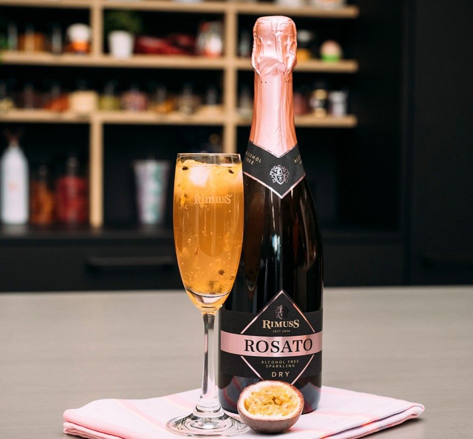 A bottle of rosato wine and a glass of wine are on a table.