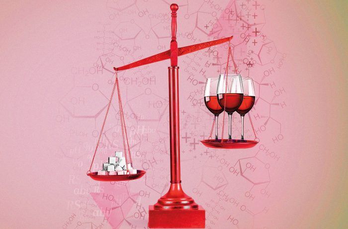 A red scale with two wine glasses and sugar cubes on it.