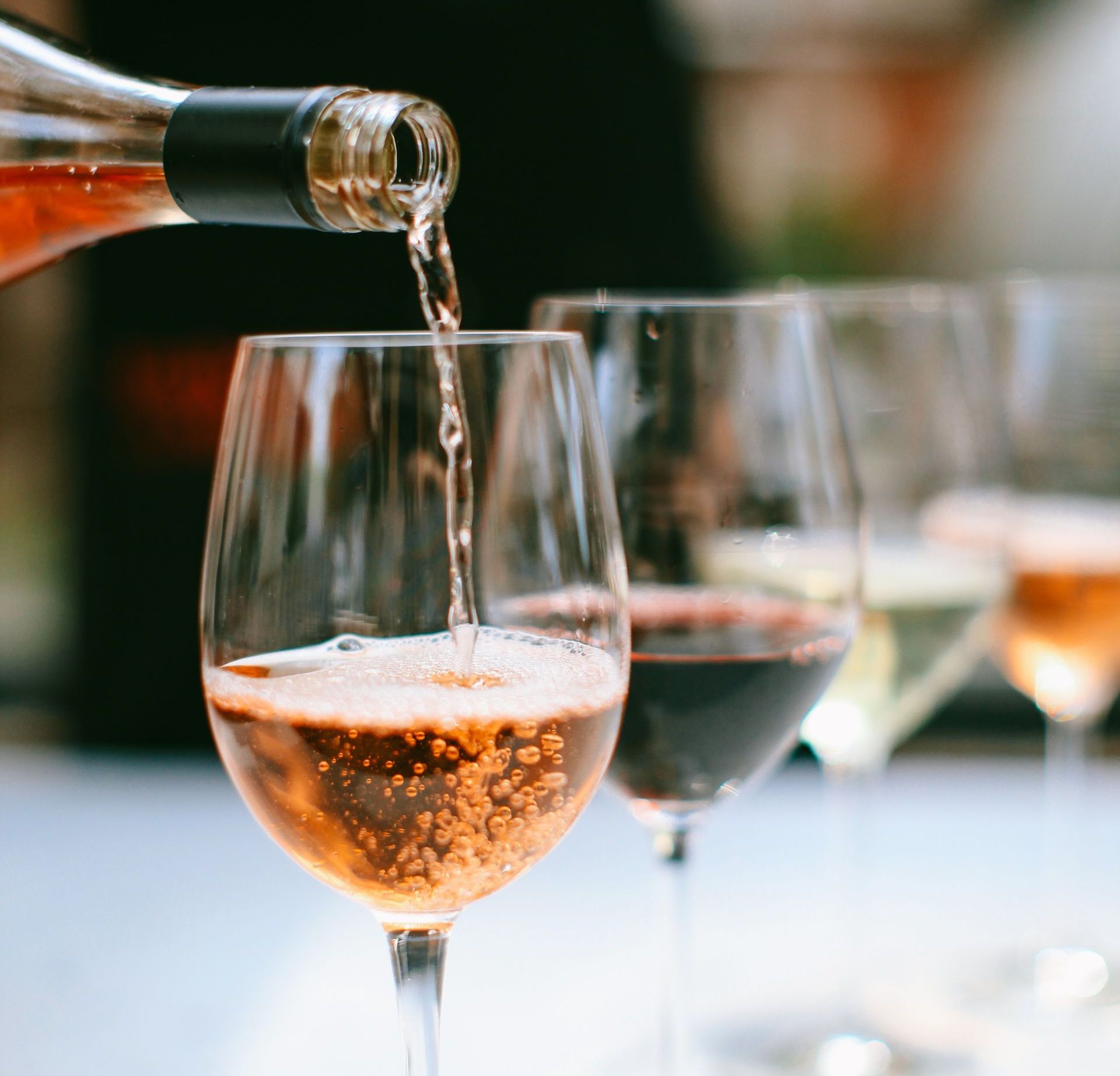 A bottle of wine is being poured into a wine glass