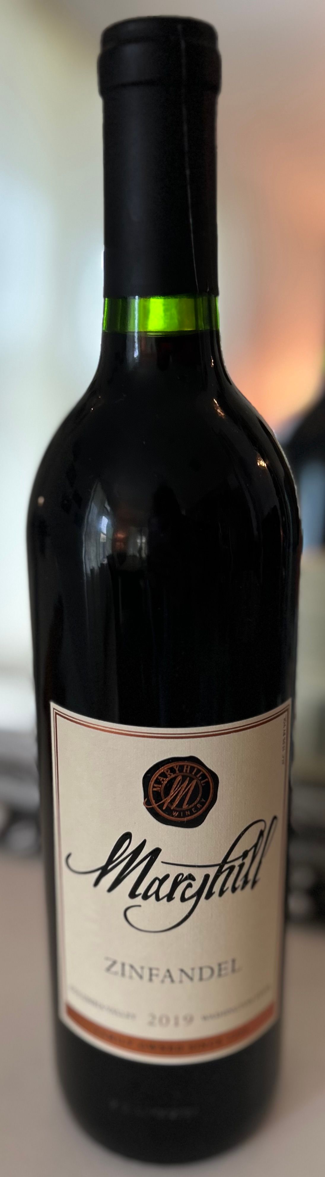 A bottle of wine with a green ribbon around the neck