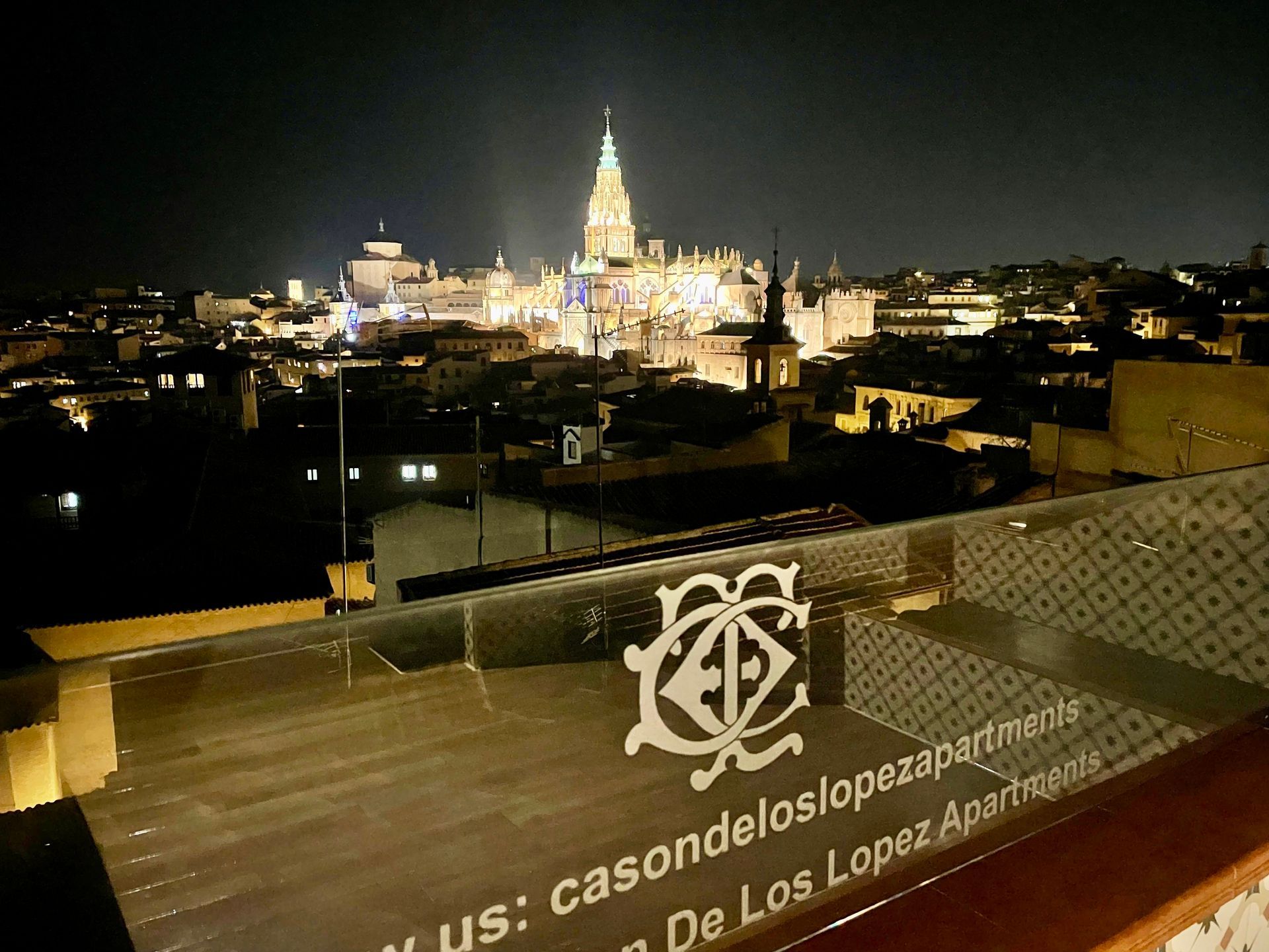 Vista nocturna de Sevilla, España, con la catedral iluminada y el logotipo de 