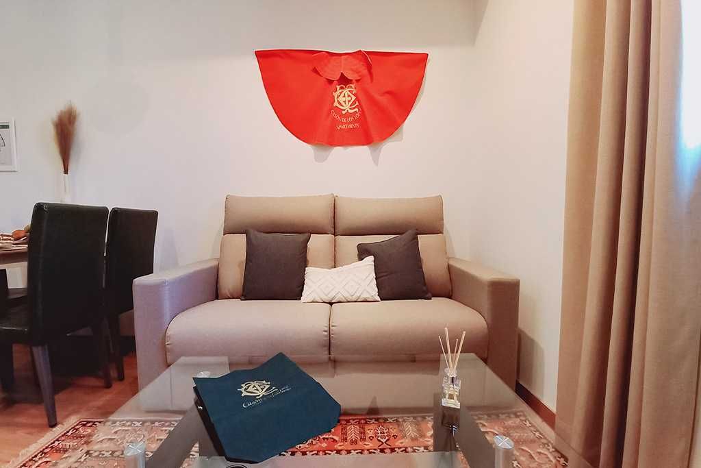 Sala de estar con sofá, mesa y decoración roja.