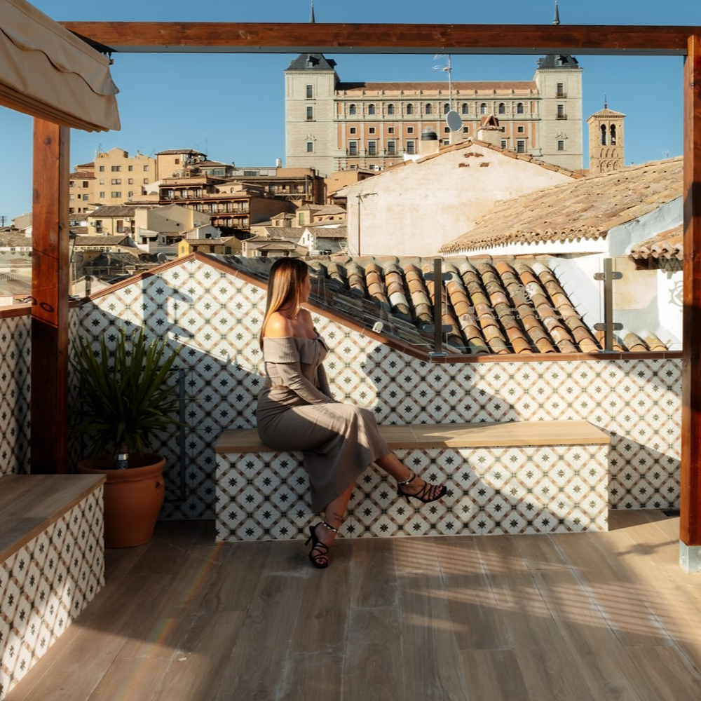 Mujer en un banco de la azotea con vistas a Toledo, España.