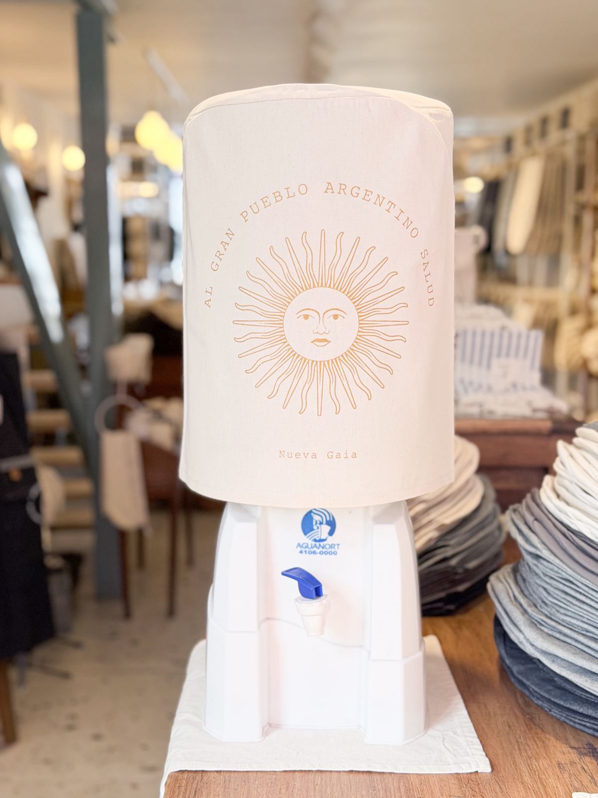 Dispensador de agua de marca argentina con tapa gris en un expositor de tienda, centrado en la imagen.