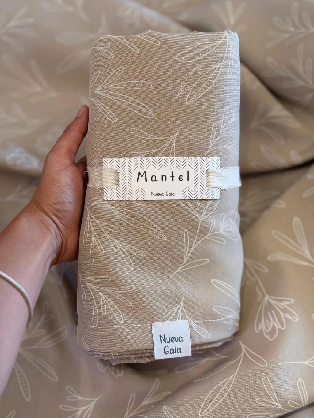 Tela texturizada de color beige doblada con la etiqueta 