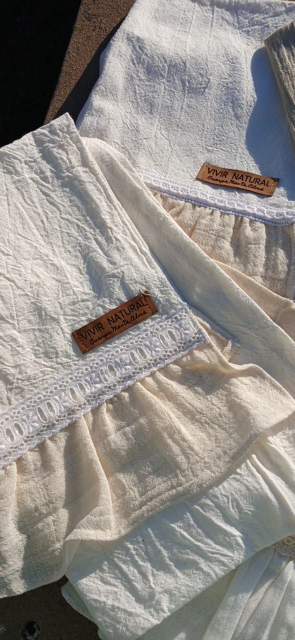 Pantalones y bermudas de tela blanca y beige con bolsillos, extendidos sobre un piso alfombrado.