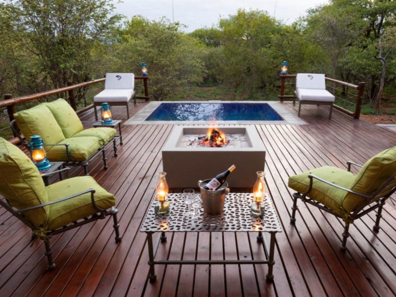 Outdoor deck with seating, small pool, fire pit, and surrounding trees.