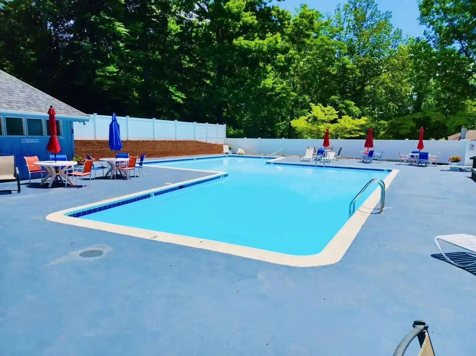 Relaxing community pool area with seating and umbrellas
