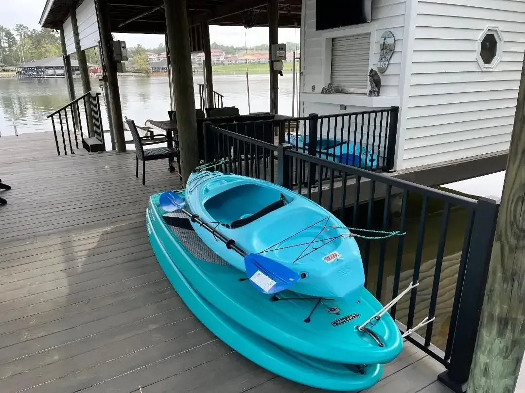 Kayaks on a lakeside dock with seating area and water view