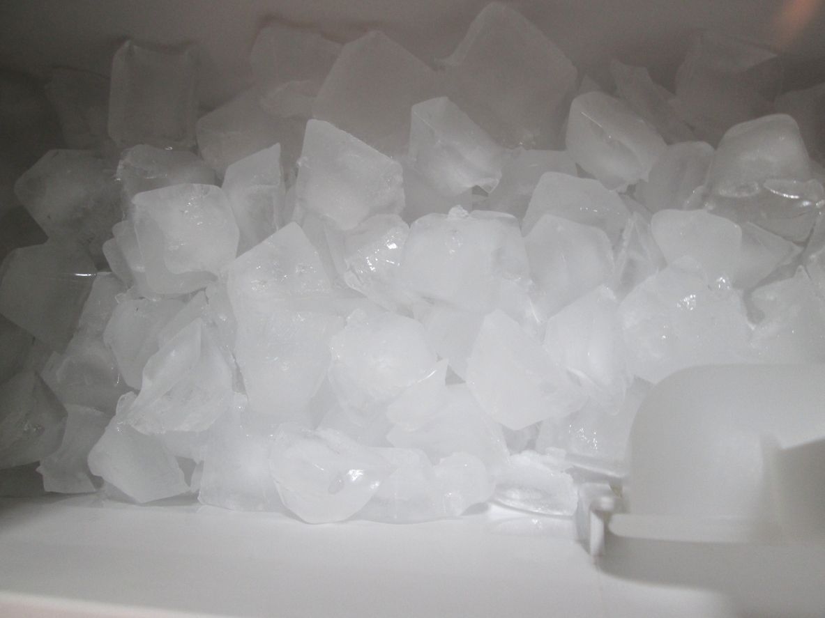 Pile of translucent ice cubes in a freezer compartment