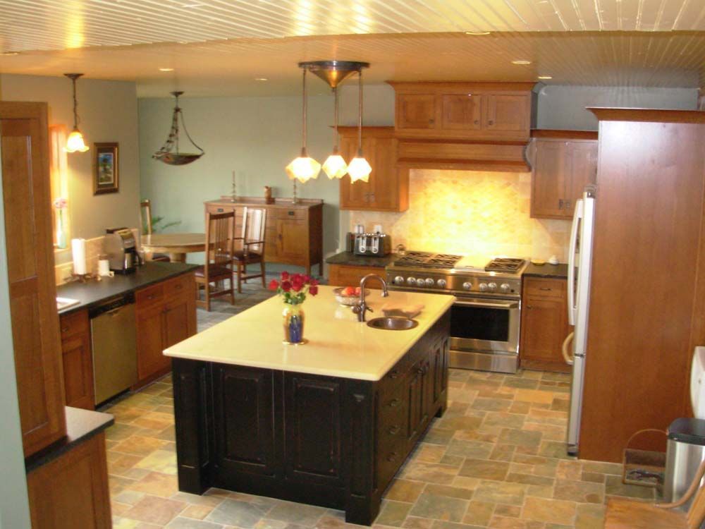 Spacious kitchen with a central island, wooden cabinets, pendant lights, and tiled floor