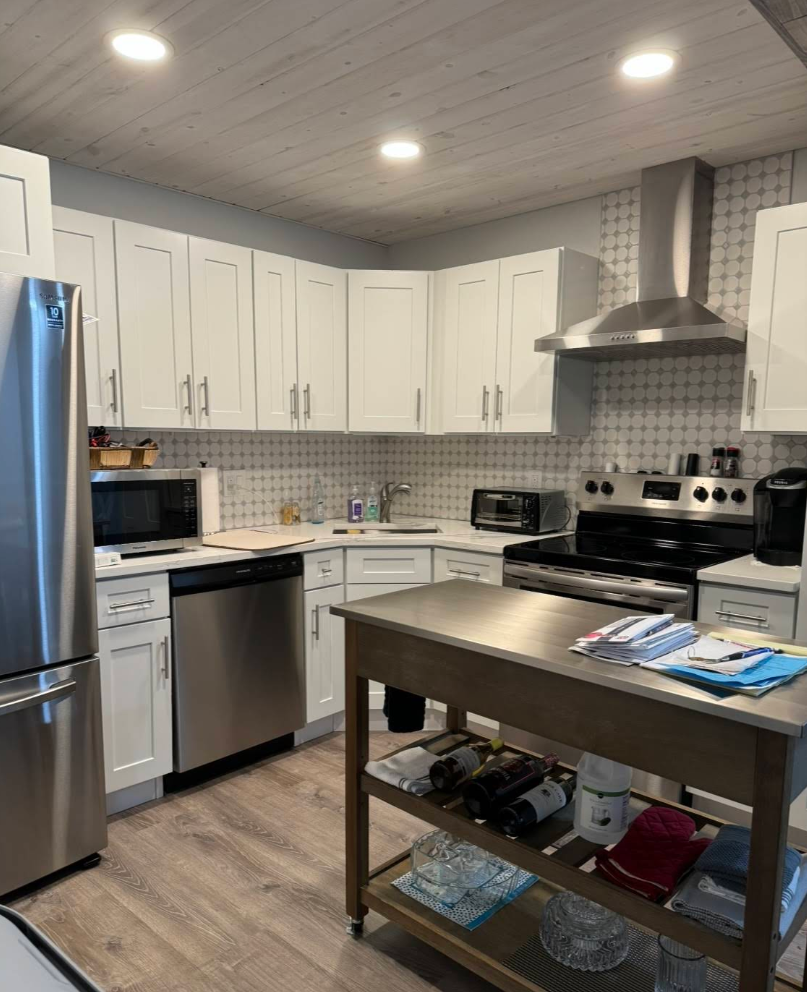 Bright, modern kitchen with white cabinets, stainless steel appliances, and a central island.