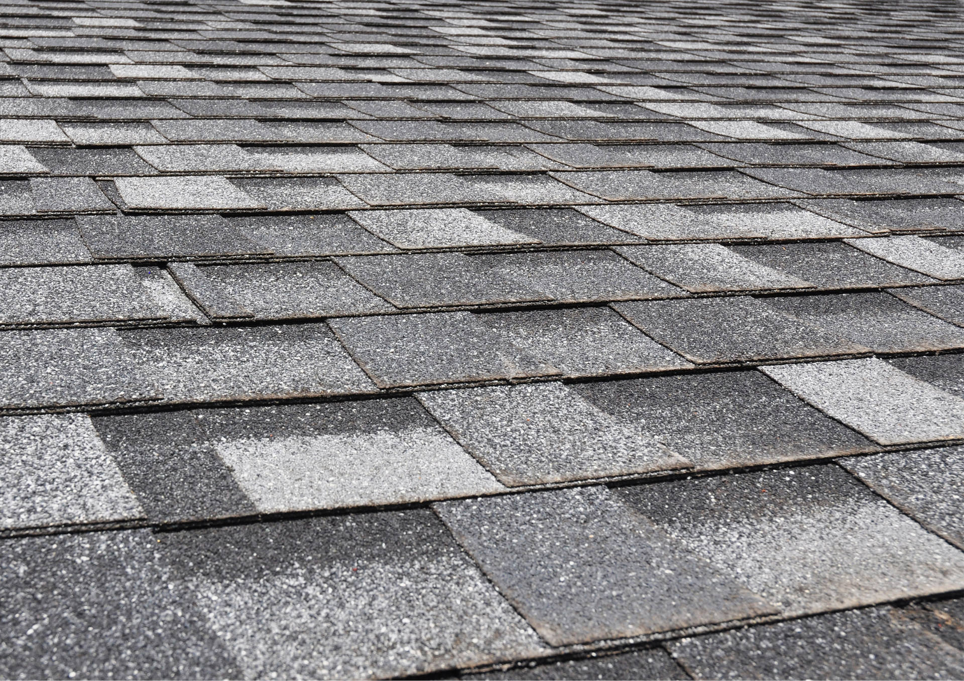 The roof of a house is against a blue sky with clouds.