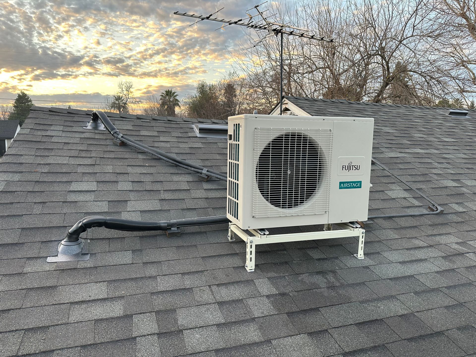 A man is working on an air conditioner with a manometer.
