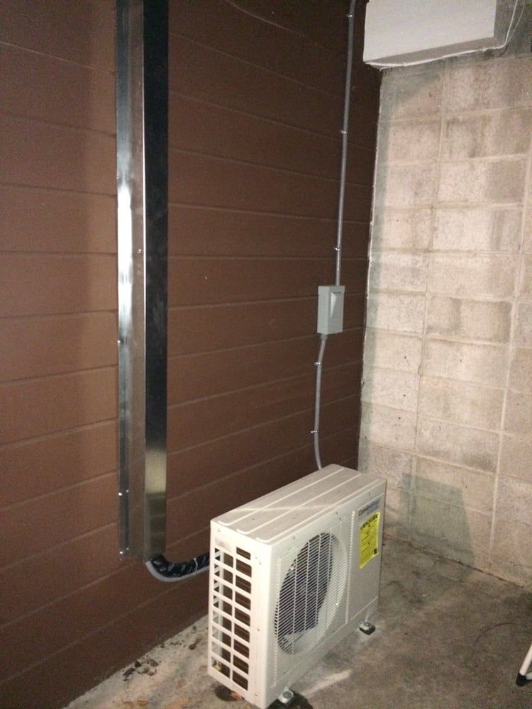 An air conditioner is mounted on the side of a building