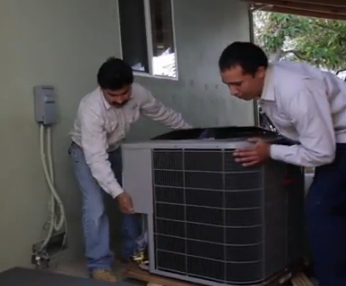 Two men are working on an air conditioner outside