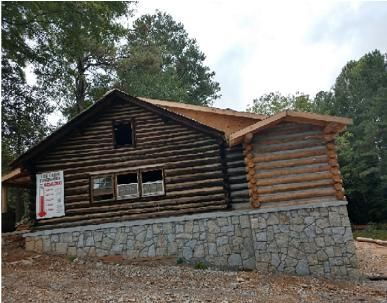A log cabin with a thermometer on the side of it