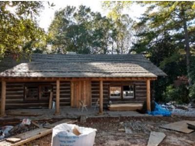 A log cabin is being built in the middle of a forest